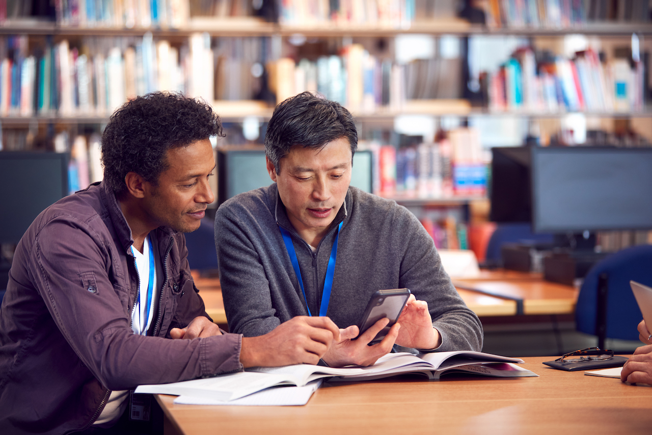 Two people studying together in a library