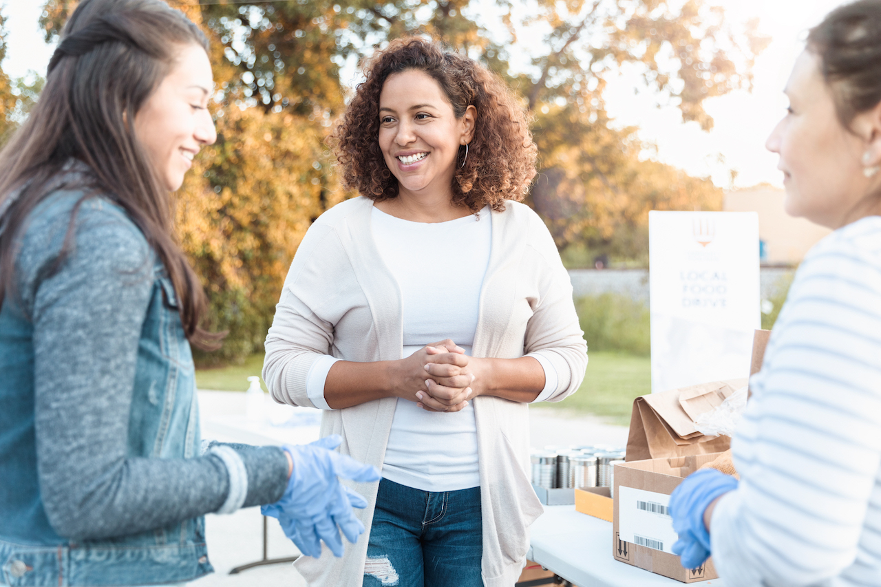 Three people volunteering at a food drive